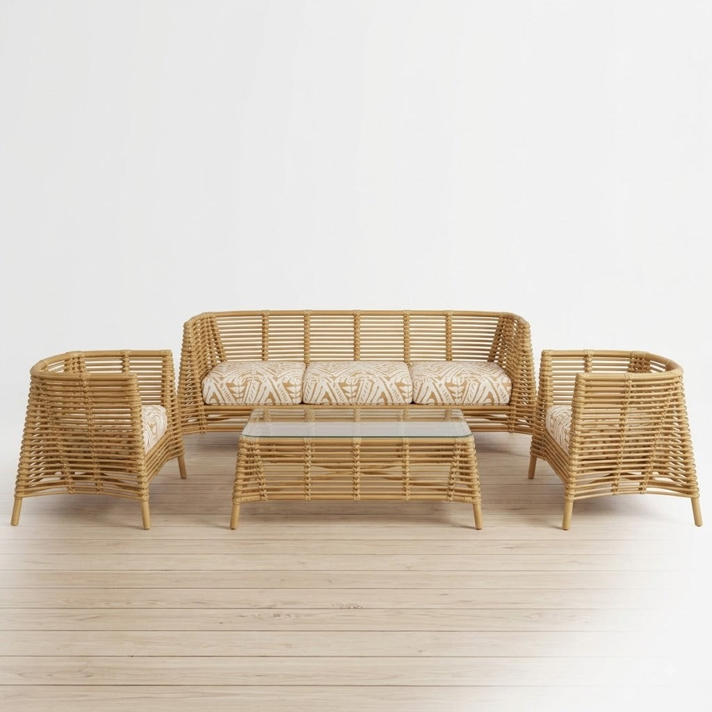 A 4-piece natural rattan outdoor furniture set including a loveseat, two armchairs, and a coffee table with a glass top, set on a light wood floor against a white background.