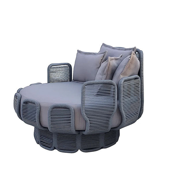 A modern round outdoor daybed with a dark gray woven frame, light gray cushioned seat and backrest, and multiple matching throw pillows, shown on a plain white background.
