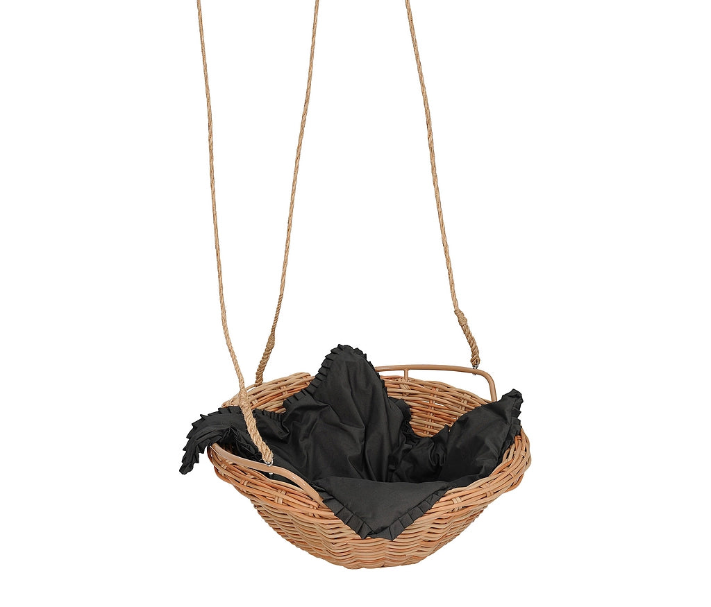 A woven wicker hanging swing seat with a natural tan rope suspension strap and a black fabric liner inside, isolated on a white background.
