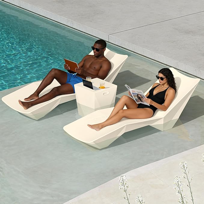 Two people relaxing on modern lounge chairs by a pool.