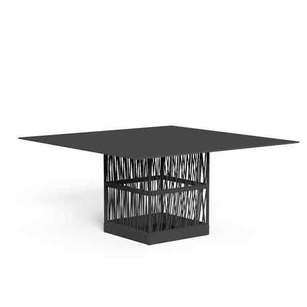A modern square dining table with a matte black top and a geometric base featuring a dense, vertical crisscross pattern of black and white metal rods, shown on a plain white background.