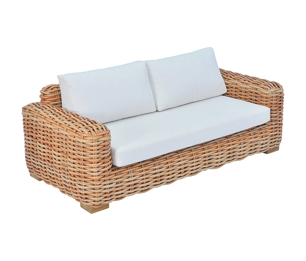 A two-seater wicker patio sofa with thick white cushions, shown from a three-quarter angle against a plain white background.