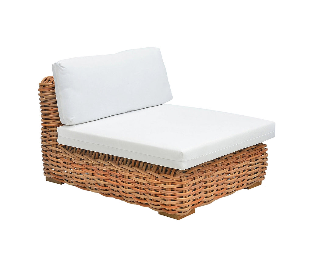 A corner outdoor chaise lounge chair with a natural brown woven wicker frame and thick white cushions on a solid white background.