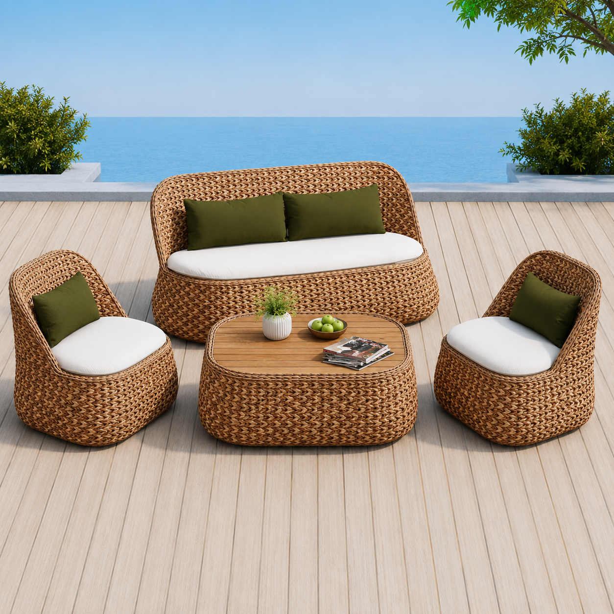 Four-piece outdoor patio furniture set with a woven wicker sofa, two matching armchairs, and a round coffee table, featuring white and olive green cushions, set on a wooden deck with a beach background.